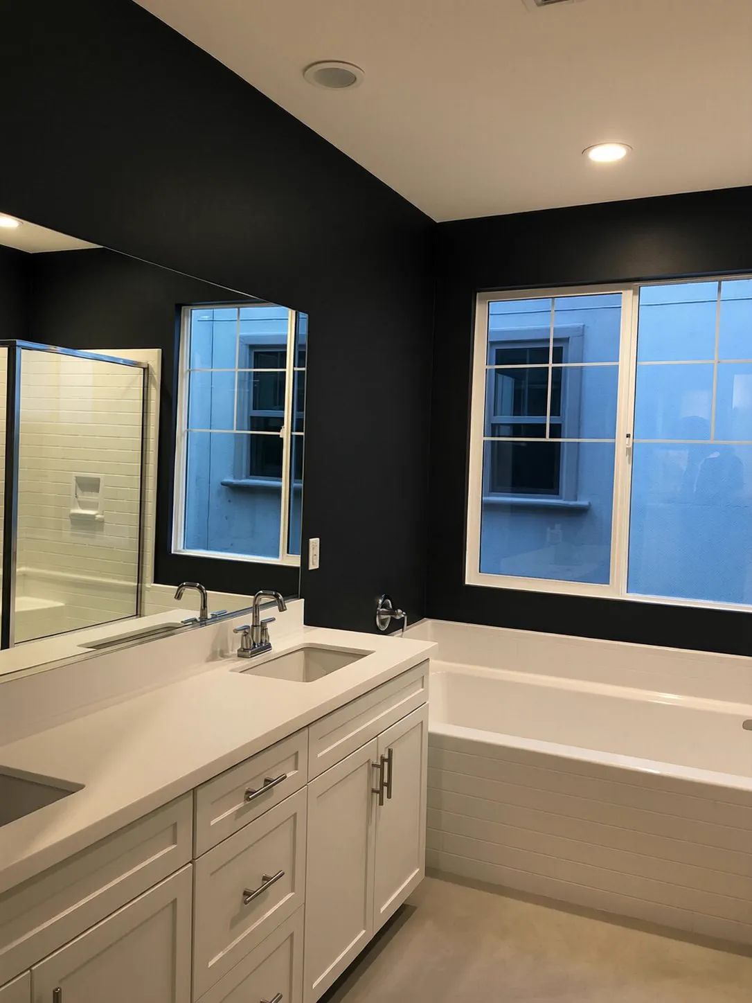 Bathroom finished in matte black paint beside a white vanity and mirror